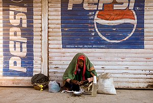 A woman waking up on a sidewalk in Bijapur, In...
