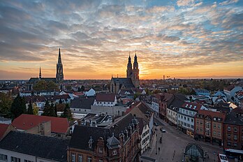 Speyer, Alemanha: vista do Altpörtel (Portão Antigo) para sudeste, sobre os telhados da cidade velha, até a igreja Memorial do Protesto (Gedächtniskirche) à esquerda e a igreja de São José (centro), atrás da qual o sol se põe. O Altpörtel era o portão ocidental da cidade de Speyer. Com 55 metros de altura, é um dos portões da cidade mais altos e importantes da Alemanha. Foi mencionado pela primeira vez em um documento em 1176 e era uma das 68 torres de muros e portões nas fortificações da Cidade Imperial Livre de Speyer. (definição 7 952 × 5 304)