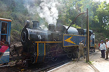 Black steam locomotive at a station