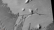 火星勘测轨道飞行器背景相机显示的奥森·威尔斯撞击坑中的沙丘，可看到细小的弯曲河道。注意，这是前一幅照片的放大图。