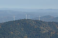 Photo aérienne du sommet ; en zoomant, on reconnaît le belvédère à gauche des deux éoliennes au centre.