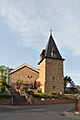 Turm der katholischen Kirche und Grabkreuze