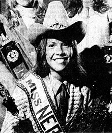 Portrait of a young girl in a cowboy hat with roses and a trophy