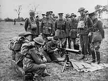 King George VI (standing centre) observes an Australian soldier assembling a machine gun while blindfolded, July 1940 King George VI watching an Australian soldier assemble a machine gun.JPG