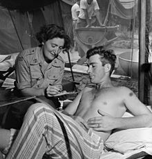 Norwegian Captain Petra Drabloe is shown with a patient, Lance Corporal M. R. Stevens of the Canadian Army during the Korean War. NORMASH nurse Korea.jpg