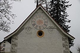 Giebel mit aufgemalter Uhr und zwei seitlichen Familienwappen