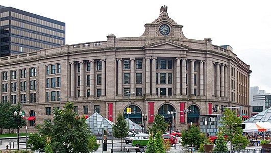A large Romanesque-style train station facade in an urban square