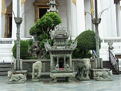 A stone Chinese temple style incense burner between two stone elephants, located at Wat Suthat