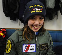 קלייר ויינלנד לבושה בחליפת טיסה של משמר החופים האמריקאי המותאמת על ידי אנשי תחנת האוויר של סיטקה במיוחד עבורה, 22 באוקטובר 2010
