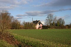 Pink-painted cottage among fields