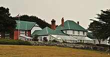 Grande maison avec des murs de pierre et une serre