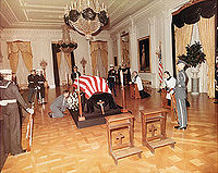 Prie-dieu facing the casket of the former US President John F. Kennedy in the East Room of the White House in 1963. The priests Robert Mohan and Gilbert Hartke are praying on two more to the right. JFK casket in White House.jpg