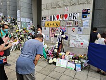 A man paying his respects to the Queen in front of a makeshift memorial at the British consulate in Hong Kong Middle-aged man paying his respect to Elizabeth II outside the British Consulate-General Hong Kong.jpg