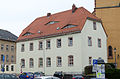 Ehemalige Schule (Rektoratsgebäude), später Wohnhaus in offener Bebauung mit Gedenktafel des Stadtbrandes von 1709 an der Traufseite des Hauses