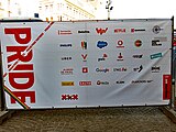Logo's van de sponsors van Pride Amsterdam, te zien op het hek van het hoofdpodium op de Dam (2018).