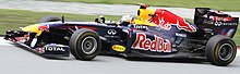 Photo of Sebastian Vettel driving a blue Red Bull car on a race track