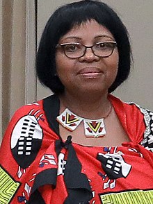 Tsandzile Dlamini 2017. Afrikanerin mit Pagenschnitt, Brille und traditionellem Schmuck