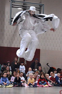 Children entertained by a stilt walker performing in a circus act Cirque Soleil Stilt 1.jpg