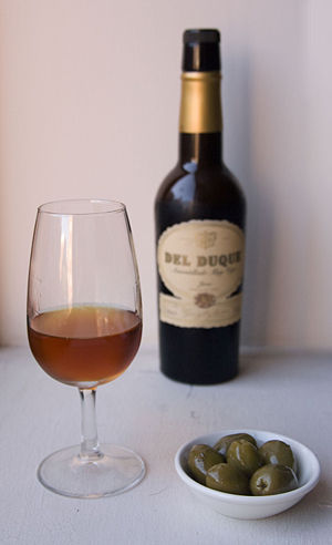 A glass of amontillado sherry, with olives