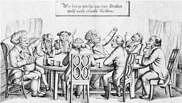 Men sitting around a table. Most of them are muzzled, some are gagged as well, some have blindfolds on, and some have their ears muffled.