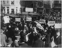 Residents of New York City celebrate the news of the Armistice of 11 November 1918. Peace rumor, New York. Crowd at Times Square holding up Extras telling about the signing of the Armistice. The... - NARA - 533477.tif