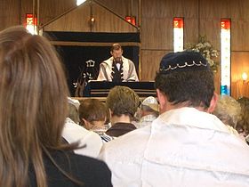 Contemporary Reform service held in Sinai Synagogue, with some congregants wearing head coverings and prayer shawls. ReformJewishService.jpg