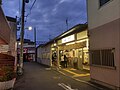 柴崎駅南口（下り方面） 改札前まで建物が迫り、奥には居酒屋が見える。