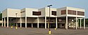 Southdale Library, a modern-style white building in an inverted step sequence supported by pillars over its parking lot on a sunny day