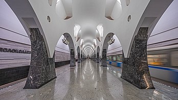 Estação de metrô Volokolamskaia em Moscou, Rússia. Inaugurada nesta data há 12 anos, Volokolamskaia tornou-se uma das mais belas estações de metrô da cidade no período pós-soviético. O projeto, desenvolvido por uma equipe de arquitetos da JSC "Metrogiprotras", venceu o concurso do Sindicato dos Arquitetos de Moscou "Golden Section 2011". As abóbadas altas (8,1 m) com arcadas formam uma composição neogótica de três naves desenvolvida verticalmente. A solução figurativa e artística leva em consideração a localização da estação na zona de proteção natural. As colunas, revestidas de mármore escuro e granito, lembram troncos de árvores. No vão central acima das colunas, nas abóbadas, existem quatro caixotões de luz simétricos em forma de folhas de árvore. De acordo com dados de 2014, o tráfego de passageiros da estação foi de 21 900 passageiros por dia. (definição 7 833 × 4 406)