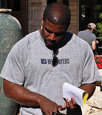 As one of the league's top backs, in 2003 Priest Holmes set the NFL rushing touchdown record (27) for a running back in a season. Priest Holmes speaks with soldiers CROPPED.jpg