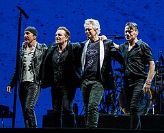 U2 in November 2019 (from left to right): The Edge, Bono, Clayton, Mullen U2 in Sydney (49139991797).jpg