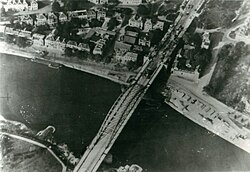 צילום אוויר של גשר ארנהם במהלך הקרבות. בקצהו הצפוני (העליון) של הגשר נראים שרידי רק"ם גרמני שנפגע בקרב