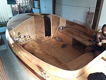 veleiro catboat de compensado naval sendo construído numa garagem no Brasil