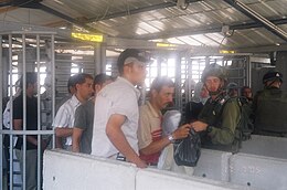 Huwwara Checkpoint, one of many Israeli checkpoints and closures (dismantled 2011 ) that restricted the movement of Palestinians in the occupied West Bank and have been compared to the apartheid pass laws Huwwara Checkpoint July 2005.jpg