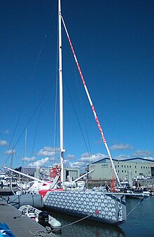 Voilier gris amarré au ponton, vu de trois quarts avant.