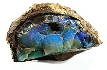 A blue-green section of opal encased inside a light brown rock
