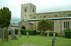 The western part of a stone church seen from the south with a clerestory and a battlemented west tower