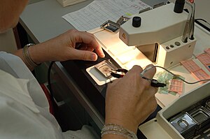 Histologic sample being embedded in paraffin wax (tissue is held at the bottom of a metal mold, and more molten paraffin is poured over it to fill it). Tissue processing - Embedding station.jpg