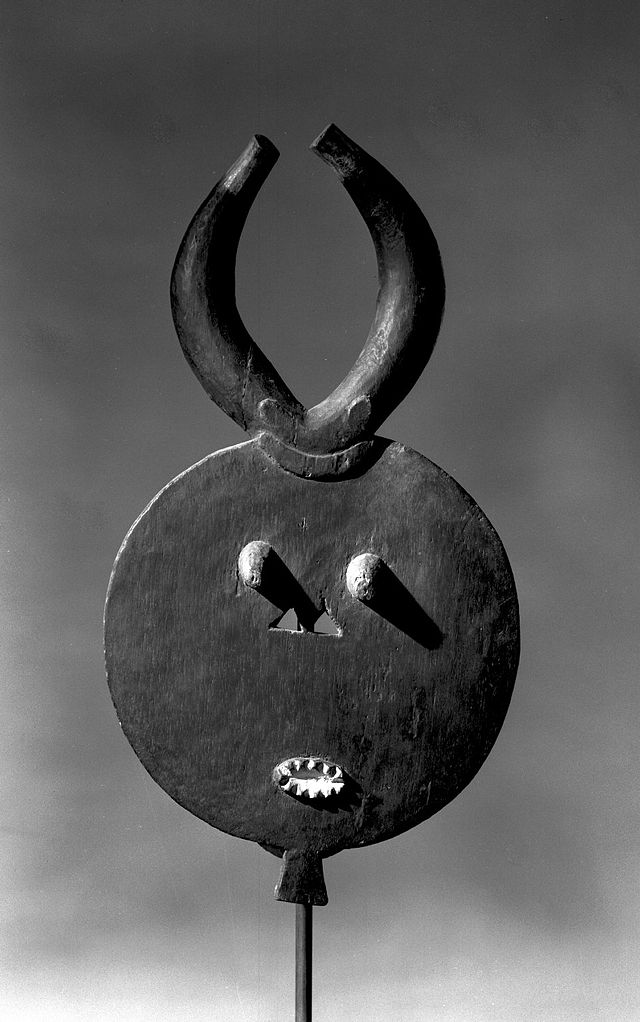 Mask with round face, small eyes and mouth, and horns.