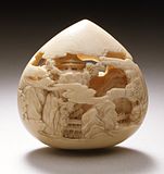 Jewel of Wisdom carved with mountain pavilions. Stained ivory