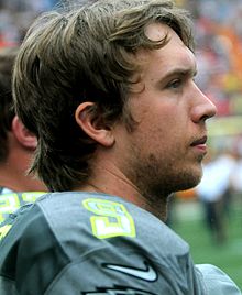 A man looking to the right and wearing a gray jersey with a silver number "9" on the shoulder.