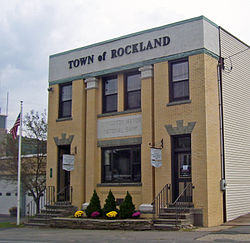 A square-fronted building in gold brick with two central pilasters. "Town of Rockland" is in large letters across the top, with "Livingston Manor National Bank" in small letters close to the ground floor