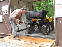 Rider cleaning an ATV at a U.S. Forest Service pressure washer station to prevent the spread of invasive plants. TV rider using power wash station.jpg
