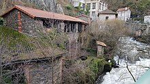 photo en automne du bâtiment d'une ancienne coutellerie en aval de l'usine du Creux de l'enfer. La bâtisse sur 2 niveaux en pierres de schistes brunes vient d'être en partie restaurée, sa toiture de tuiles est neuve mais il n'y a encore aucune huisserie aux fenêtres