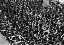 Detail fotografie, kde jeden muž v davu odmítá pozdravit nacistickým pozdravem; pravděpodobně se jedná o Augusta Landmessera.