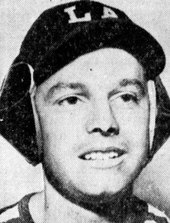 Los Angeles sportswriter Bob Hunter modeling a new baseball helmet in 1939. The helmet's design is similar to earmuffs and fits over the baseball cap. Bob Hunter LA sportswriter.jpeg