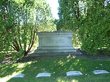 Large monument between two trees, inscribed "Charles M. Loring/Father of the Parks". Loring's grave is center left of four visible.