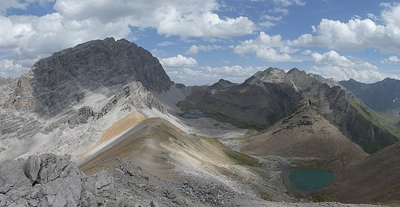 Blick nach Südosten. Im Vordergrund links Pass d’Ela, rechts der namenlose Bergsee vor dem Piz Furnatsch. Im Hintergrund v. l. n. r. Piz Ela, Fuorcla da Tschitta hinter dem Lai Grond, Piz Val Lunga, Piz Salteras, Piz Bleis Marscha, Piz Laviner und Piz Jenatsch.