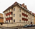 Mehrfamilienhaus einer Wohnanlage, mit begrüntem Innenhof, Vorgarten und Einfriedungsmauer