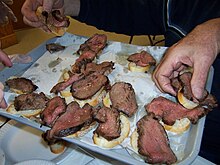 Diners reach for the beef tenderloin slices being proffered on a tray